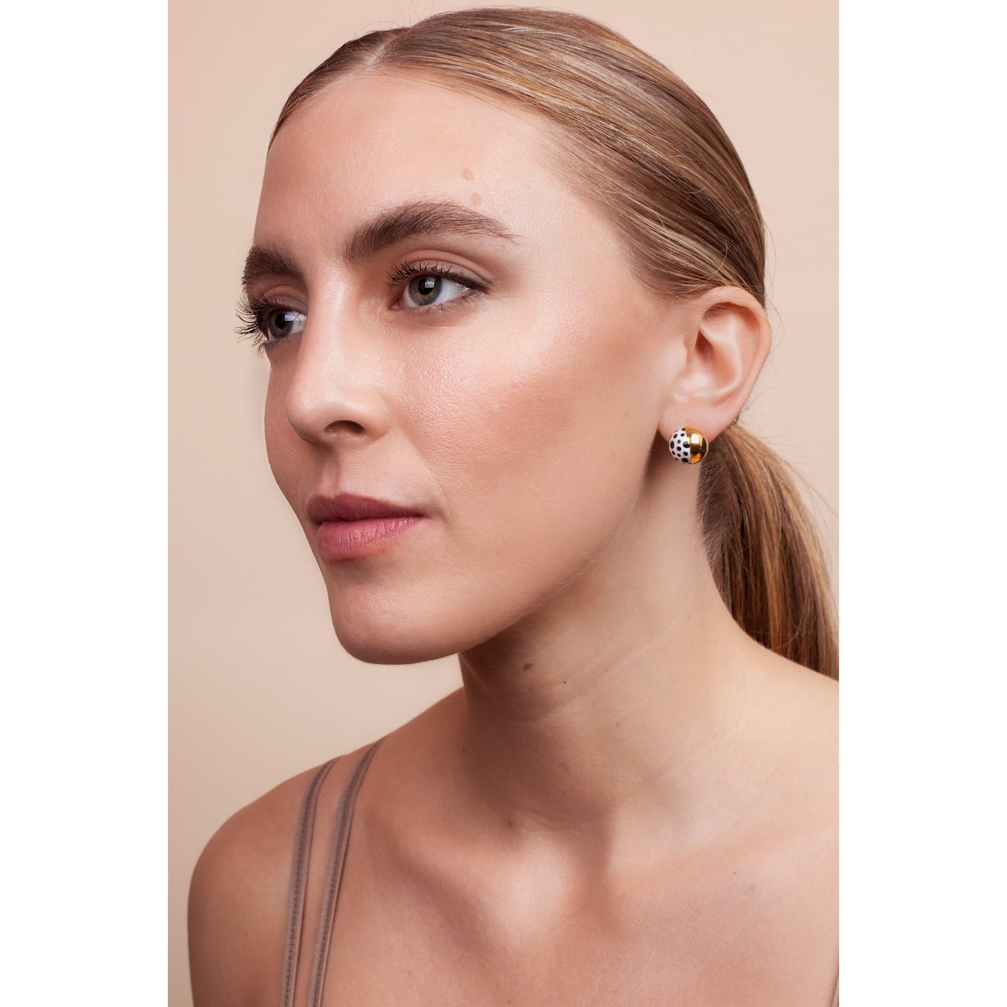 Tara wearing large polka dot stud earrings